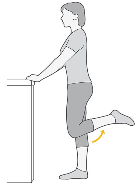 An illustration of someone standing whilst holding onto a table, bending their knee towards their bottom.