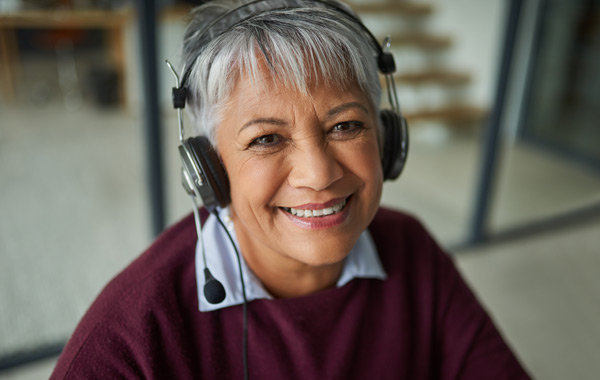 A lady wearing a headset smiling at the camera.