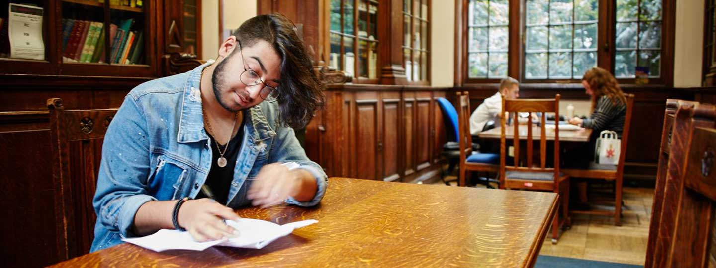Young man making notes in cafe.