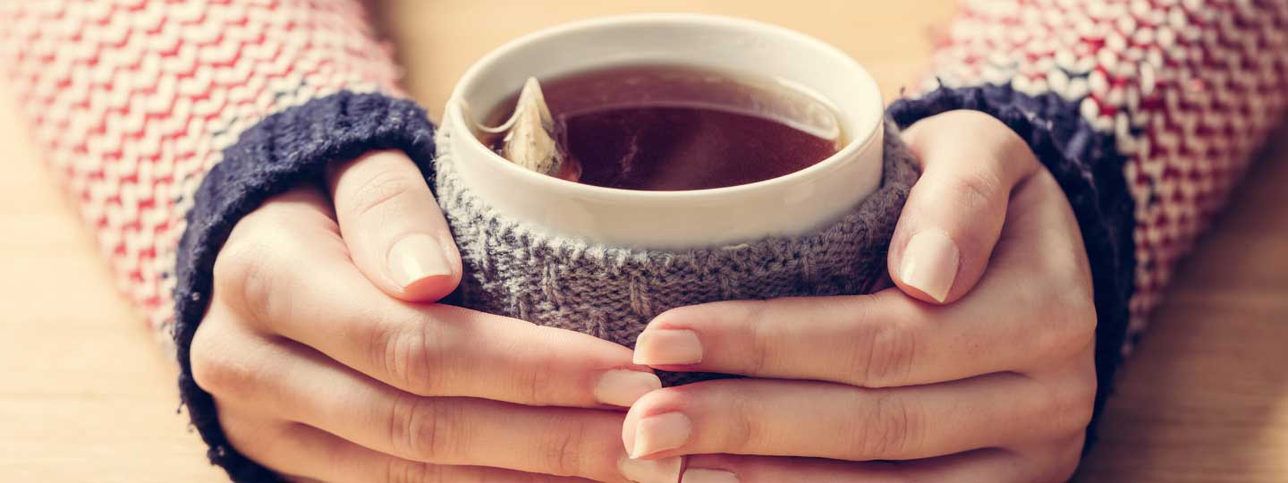 Hands holding a hot drink.