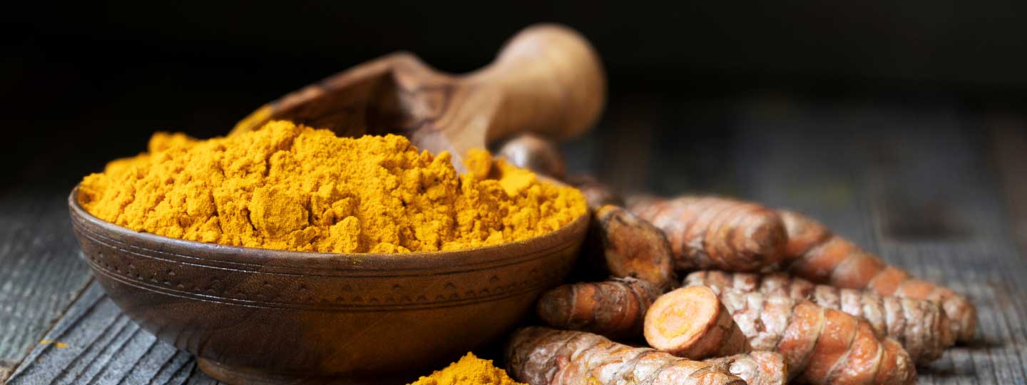 Turmeric in a bowl and turmeric root.