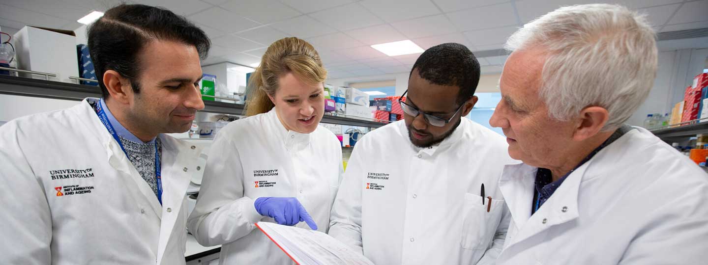 Researchers standing together studying data.