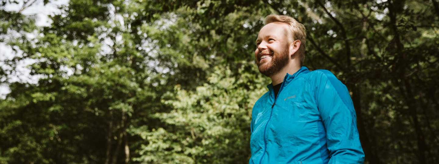 Young man called Richard standing outside standing near trees.