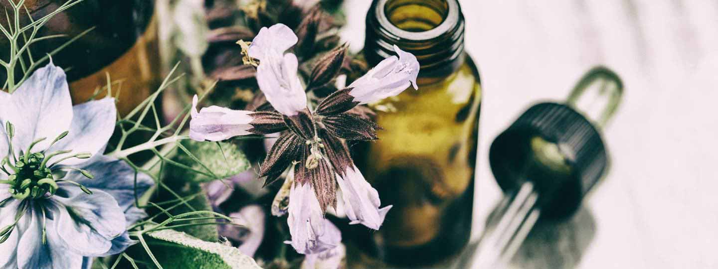 Flowers, a bottle and a pipette signifying complementary and alternative medicines.