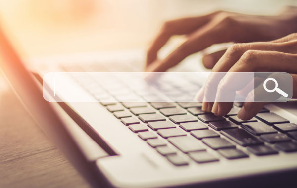 A person's fingers tapping on a computer keyboard