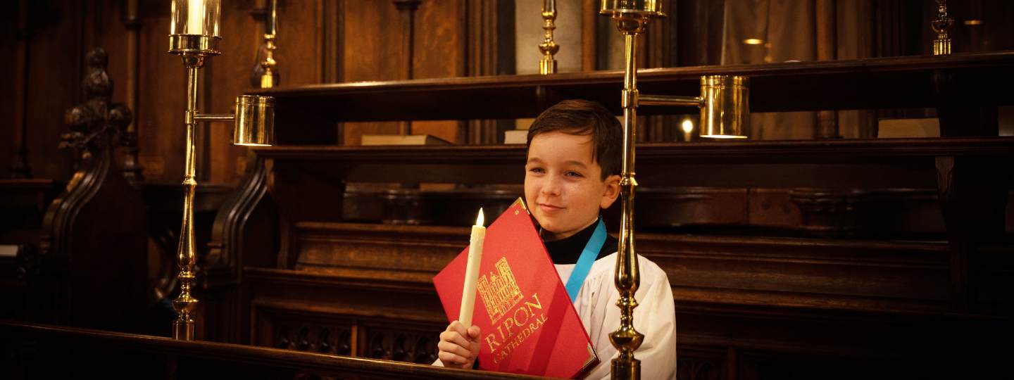 Young child in choir holding a candle 