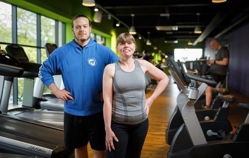 A woman in the gym with her personal trainer