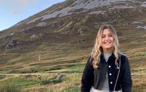 Smiling girl standing in front of mountain