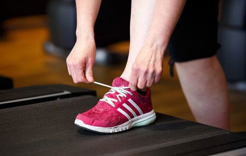 Woman tying shoelace of trainers