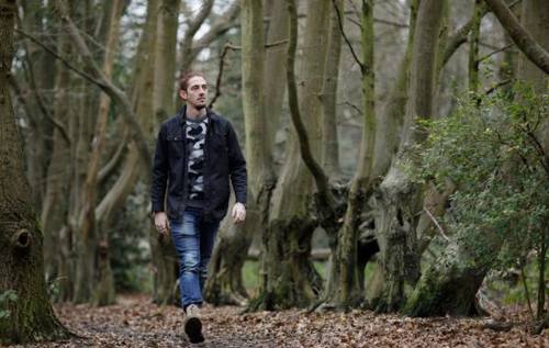 Young man walking in a lush green forest