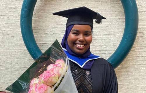 Smiling girl on her graduation day holding flowers