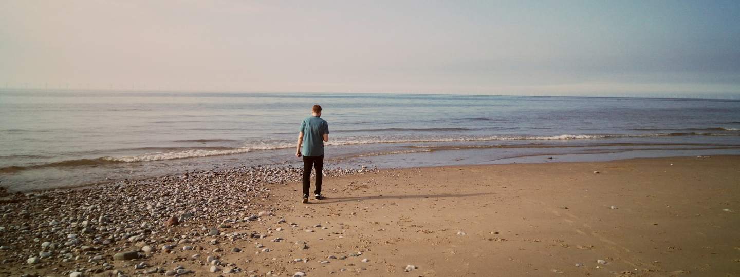 Young man walking on beach