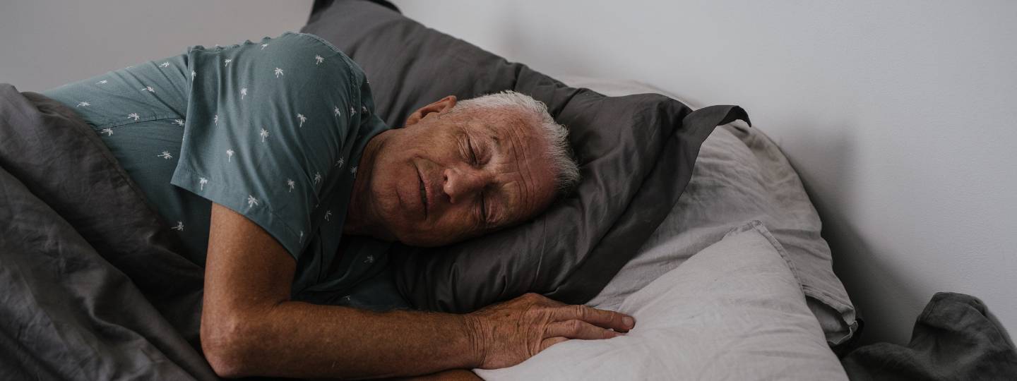 Older man sleeping peacefully in bed