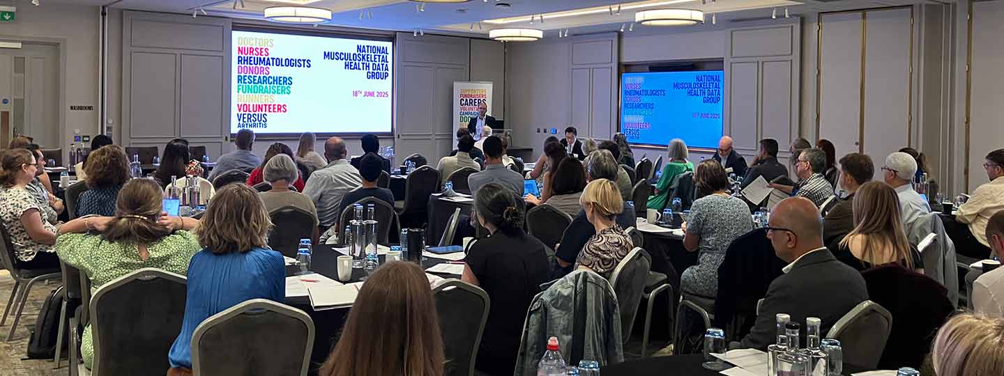 A large audience listens to a presentation at the National MSK Health Data Group Event