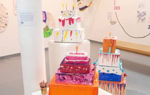 Three handmade cake sculptures in an art exhibit