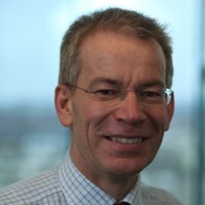 Smiling Graham wearing glasses and a white checked shirt