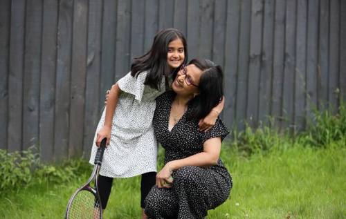 Sfiyah hugging her mum holding a tennis racket