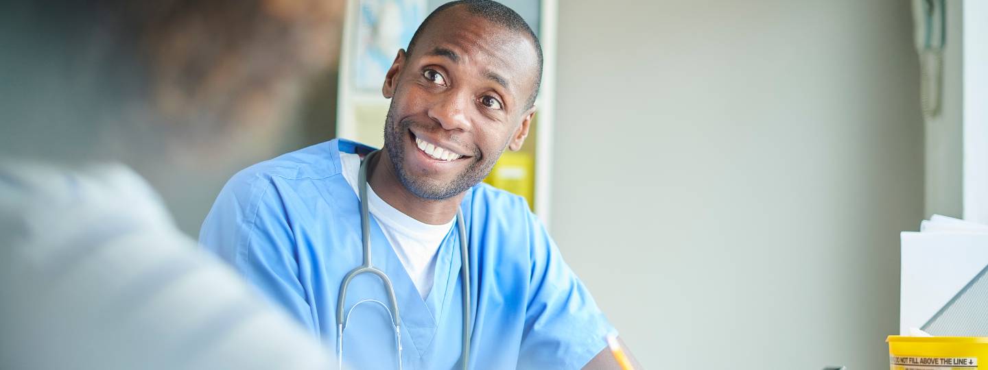 Smiling doctor wearing stethoscope talking to patient