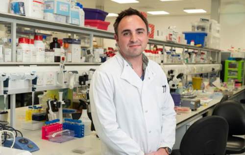 Dr David Wilkinson wearing laboratory coat standing in lab