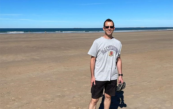 Jon Standing On A Beach In The Sun