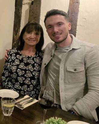 Lewis wearing a grey jacket with his arm around his mum Jackie at a restaurant