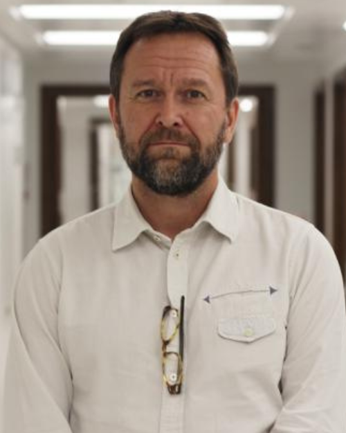 Paul Brogan wearing white shirt in hospital