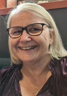 Smiling photo of Gillian who wears glasses